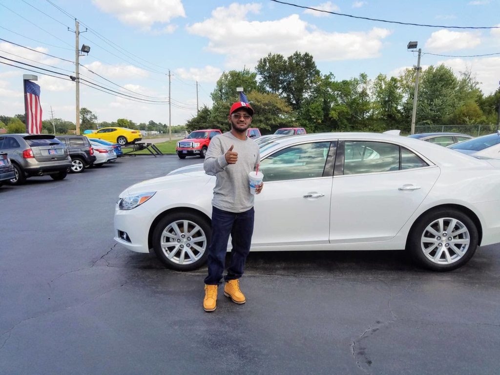 Green Light Auto Customer showing Thumbs up in front of new car