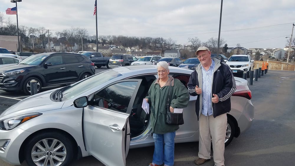 Happy customers with their new car