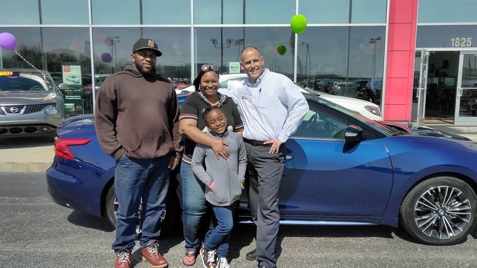 Green Light Auto Mother Father and Daughter with Salesperson Excited About New Car