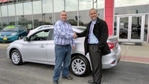 Two Happy Men outside car dealership with new car in st louis