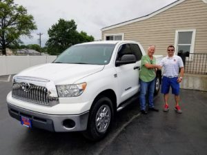 Green Light Auto Customer with White Toyota Truck and Salesperson