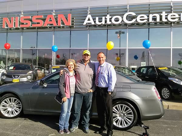 Green Light Auto Sales Two Happy Customers with Salesperson