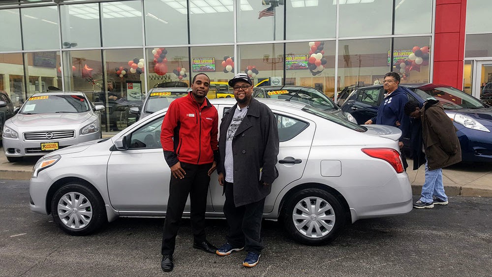 Green Light Salesperson and New Nissan Versa S Owner with people walking