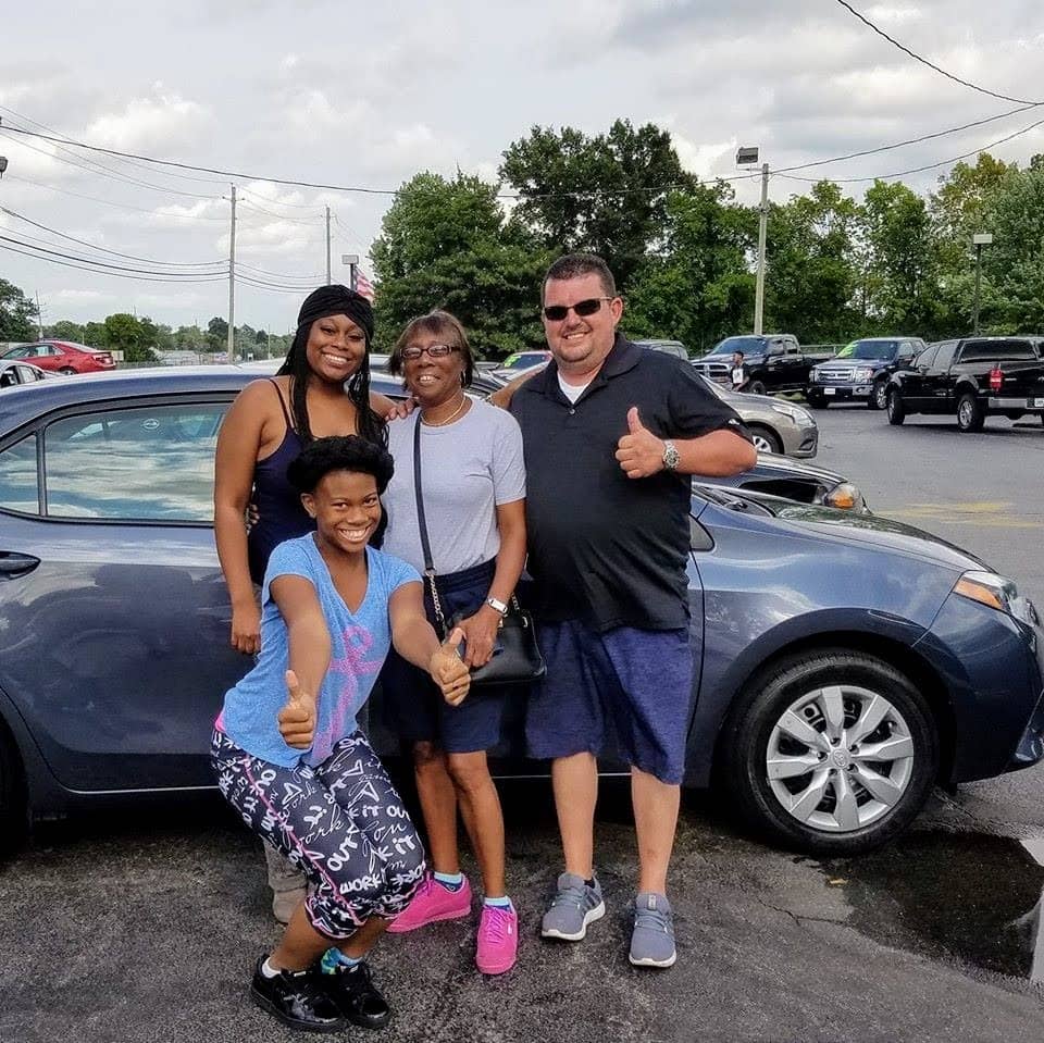 Green Light Auto three happy customers with new Toyota and salesperson