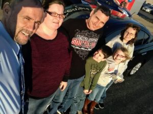 Green Light Auto Credit Family happy with their new black sedan